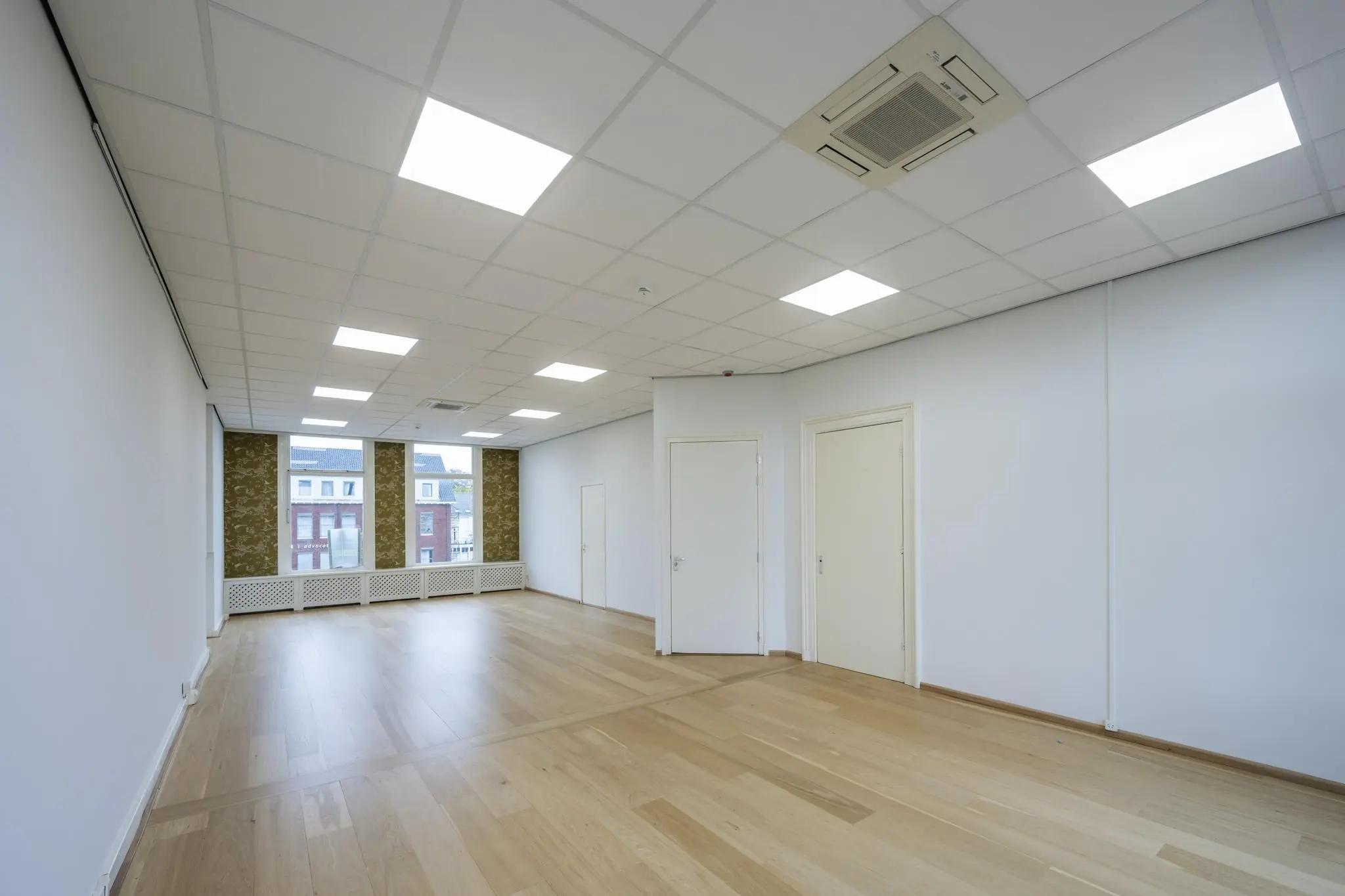 Licht en modern kantoorruimte aan de Nieuwe Gracht met houten vloer, systeemplafond en grote ramen.